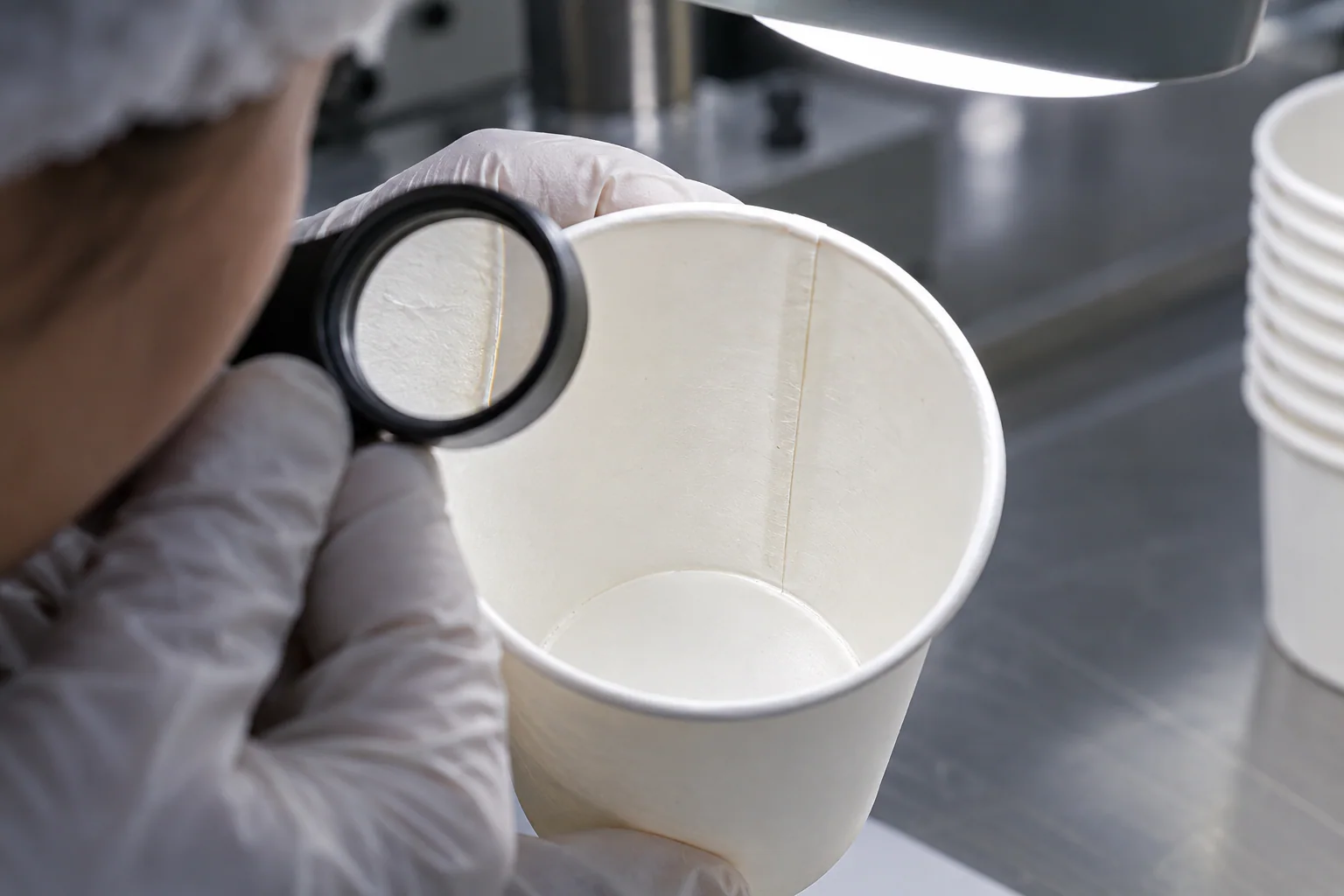 Inspector checking double PE coating and seam quality related to ice cream cup condensation